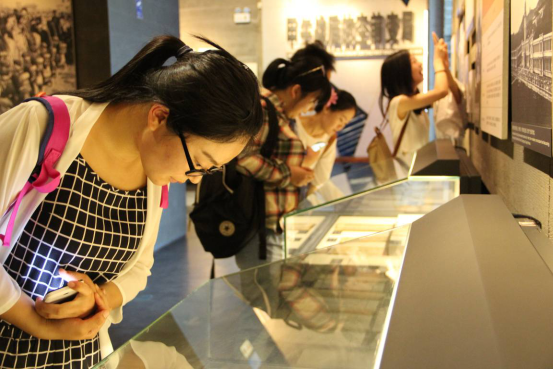 党支部成员在展厅里仔细观看陈列文物。/摄影:崔慧莹